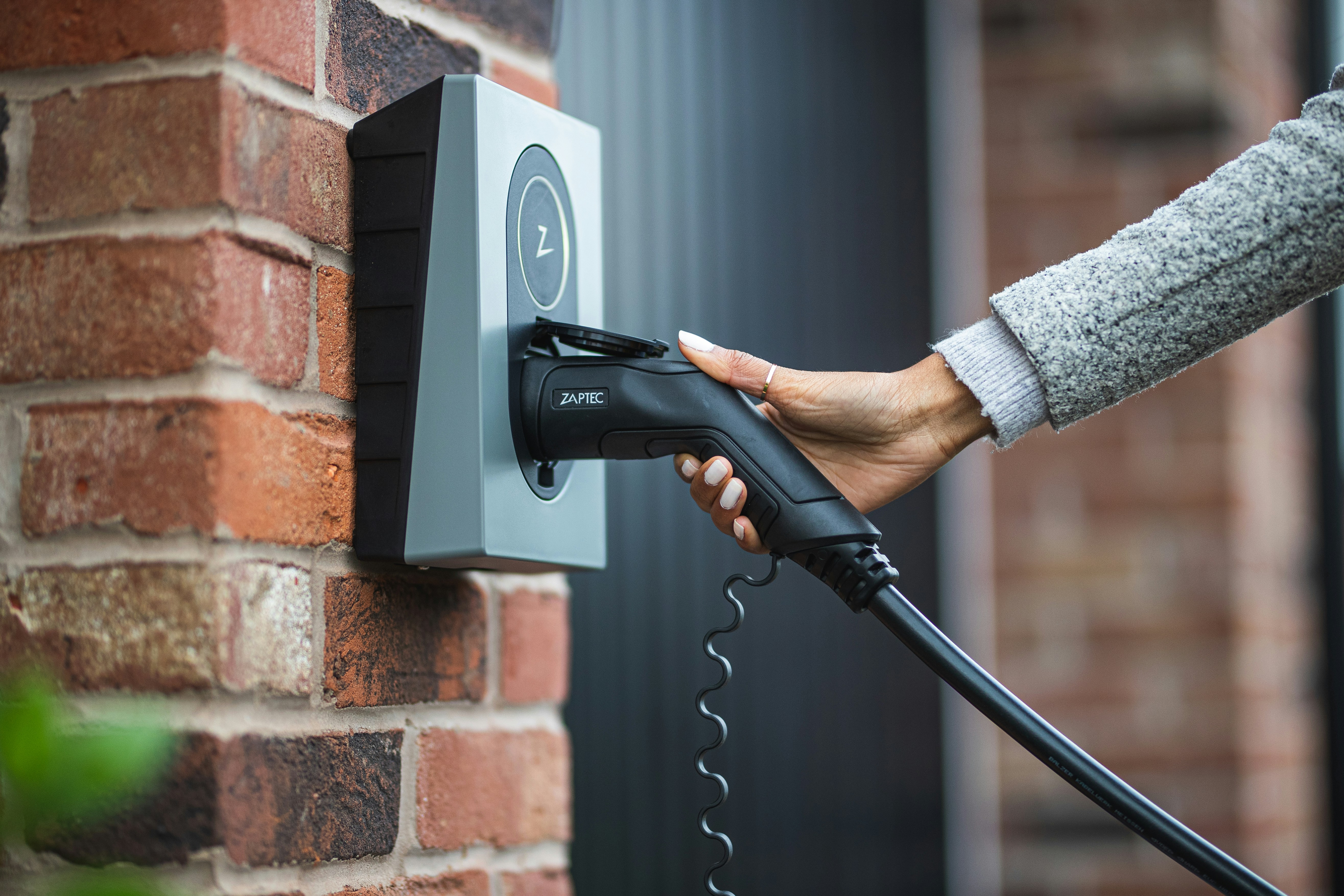 An EV charger being plugged in at a home